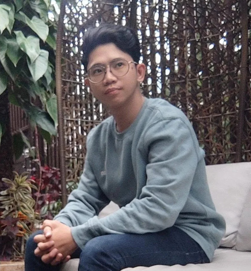 Norman Lim sitting on an outdoor sofa in a garden
